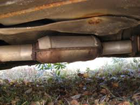 Katalysator och avgasrör på undersidan av en bil